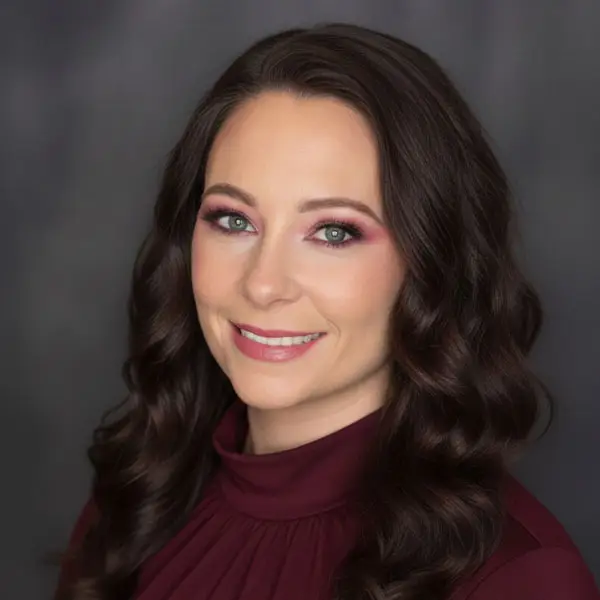 Woman with wavy hair in burgundy top